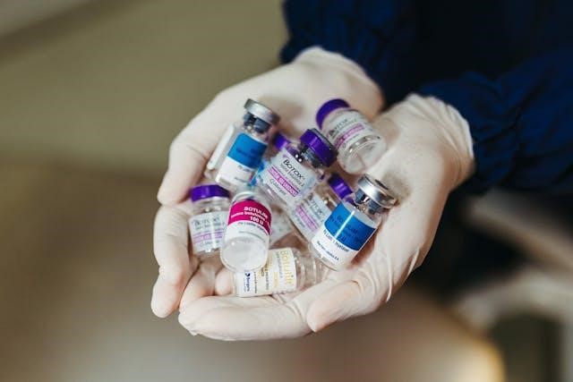 Different Botox flasks held by a person with white gloves